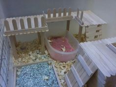 a toy house made out of wooden pallets and other items in the process of being put together