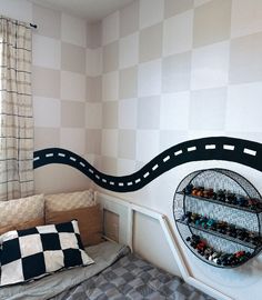 a room with a bed, checkered wall and shelves