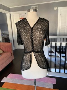 "1930's sheer black lace short sleeve blouse with a high low hem. Black covered buttons up the front. In largely good condition, but does have two holes in the lace, one at the waist and a large hole in the right shoulder. See all photos Womens small 34\" bust 28\" waist 17\" shoulder to waist seam 15\" back waist to the back hem" Goth Things, Faux Fur Hooded Coat, Black Lace Shorts, Black Lace Blouse, Lace Short, Black Cover, Womens Blouses, Hooded Coat, Lace Blouse