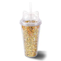 a plastic cup filled with gold flakes and a straw sticking out of the top