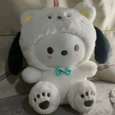 a white stuffed animal with a green bow tie on it's head and feet