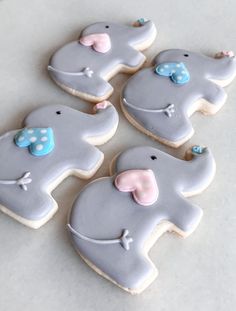 four decorated cookies in the shape of elephants