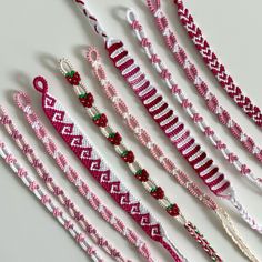 several pink and white beaded bracelets on a table