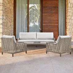 two chairs and a couch sitting on top of a patio