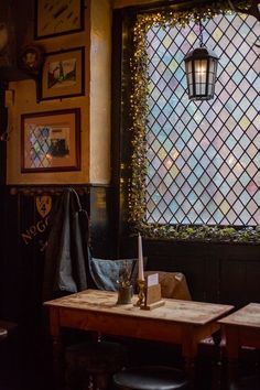 a table and two chairs in front of a window with lights on the outside wall