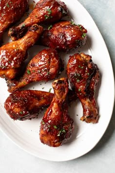 chicken wings covered in bbq sauce on a white plate