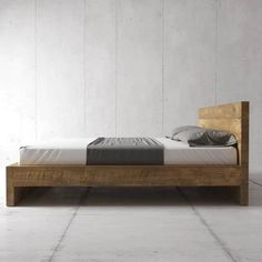 a bed that is made up and sitting in the middle of some white flooring