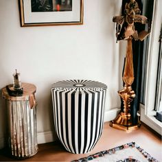 a black and white striped stool next to a gold statue