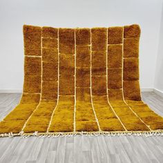 a yellow rug on the floor in an empty room