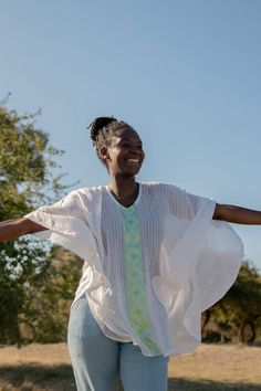 Your search for the perfect flowy top that billows effortlessly in the wind ends here. The Fifi top is the ultimate resort wear for when you're frolicking on the beach or dancing through a sea of people. Featuring tonal stripes and a geometric pattern inspired by Habesha Kemis, the traditional dress of Ethiopian women. Style Details: 100% Cotton Handwash Made in Ethiopia Menby Design Fit Details: One size fits all Breezy V-neck Tops For Beach, Flowy White Top For Beach Cover-up, Flowy V-neck Tops For Beach Cover-up, Beachy Upf 50+ Tops For Spring, Flowy White Breezy Cover-up, Summer Beach Cover-up Flowy Blouse, Striped Tops For Spring Beach Occasions, Striped Beach Tops For Spring, Spring Striped Beach Tops