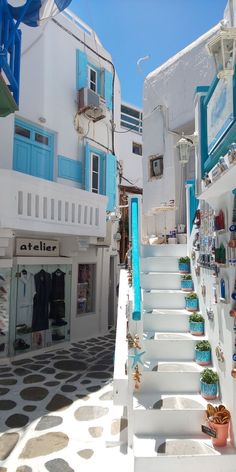 an alley way with white buildings and blue shutters