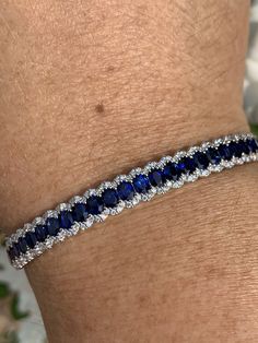 "Gorgeous Sapphire and Diamond Bracelet. The blue sapphires are a deep blue color with lots of life to them; all well matched. All REAL stones. You can tell it's blue right away, unlike some sapphires that are so dark they look black. Excellent craftsmanship, the row of blue sapphires are framed on each side by a scalloped row of sparkling diamonds. All stones are set smooth. The lock is easy to work and very secure with safety latch. The width measures 7mm. Will fit 7\" wrist comfortably. One O Blue Diamond Bracelet With Brilliant Cut Luxury Style, Luxury Blue Diamond Bracelet With Brilliant Cut, Luxury Sapphire Oval Bracelets, Formal Blue Sterling Silver Bangle Bracelet, Blue Bangle Tennis Bracelet For Formal Occasions, Blue Brilliant Cut Diamond Bracelet For Formal Occasions, Fine Jewelry Sapphire Bracelets, Sapphire Bangle Bracelet For Formal Occasions, Luxury Sapphire Bracelets