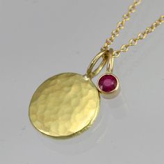 Hammered Disc with Ruby Drop Necklace in 14k Gold (16") 14k Gold Round Coin Necklace Fine Jewelry, Gold Plated Birthstone Necklace With Round Pendant, Gold Plated Yellow Gold Birthstone Necklace, Yellow Gold Birthstone Necklace With Round Pendant, Gold-plated Yellow Gold Birthstone Necklace, Yellow Gold Plated Birthstone Necklace With Round Pendant, 14k Gold Round Coin Necklace, Yellow Gold Charm Necklace With Round Pendant, 14k Yellow Gold Birthstone Necklace With Round Pendant