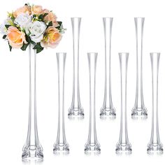 six tall vases with flowers in them on a white background and one is empty