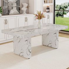 a white marble dining table sitting in front of a window