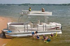 some people are standing in the water near a boat that is floating on the beach