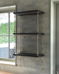 two black shelves in front of a window