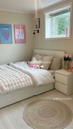 a white bed sitting in a bedroom next to a window