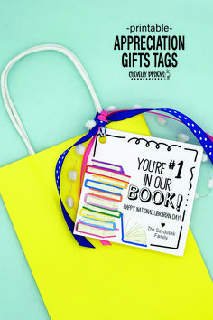 a yellow book bag with some books on it and a blue ribbon around the tag