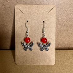 MKW Emporium Silver Handmade Beaded Charm Earrings Red Bead with a Silver Butterfly Charm #97 These are silver earrings with a red bead. It has a silver butterfly charm etched with black wings. All of the Earring Hooks used are Hypoallergenic Ear Hooks with clear silicone backings. Made of quality nickel-free and lead-free metal alloy or 925 silver-plated copper. Most Earrings can be customized and created just for you! If you have a specific color or style that you would like to see, please feel free to reach out so that your item can be made and listed. Most Earrings can be converted to clip-ons.  Please feel free to reach out with any questions. Nickel-free Casual Beaded Earrings For Gift, Nickel Free Casual Beaded Earrings For Gift, Gift Red Beaded Earrings With Ear Wire, Casual Nickel-free Beaded Earrings As Gift, Red Beaded Earrings For Gift, Casual Nickel-free Beaded Earrings For Gift, Handmade Red Casual Earrings, Handmade Casual Red Earrings, Red Dangling Beaded Earrings As Gift