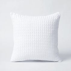 a white pillow on a white background with no one in the photo to describe it