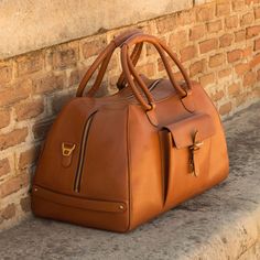 Ideal for overnight or weekend trips, the travel duffle is the best option to carry all your essentials in style. There’s virtually no place where a leather duffel bag would feel awkward or out of place. It measures 21.6 x 11.8 x 11.0 inches / 55 x 30 x 28 cm and features an outside pocket perfect for the little items that could otherwise get lost at the bottom of your bag, full lined interior and a removable shoulder strap. THE DETAILS: Materials: cognac painted calf Lining: brown fabric A uniq Designed Shoes, Leather Duffel Bag, Cheap Purses, Leather Duffel, Popular Handbags, Hot Style, Leather Duffle Bag, Leather Travel Bag, Handbags Affordable