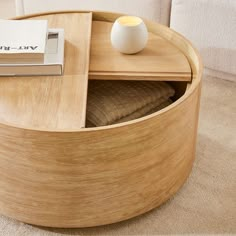 a wooden table with a book on it and a white vase next to the coffee table