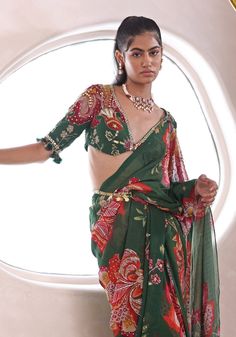 Step into effortless grace with this Green Floral Printed Pre-Draped Saree Set—your go-to for a standout Mehendi look. This ready to wear saree combines chic convenience with traditional charm, adorned with intricate embroidery. Perfectly paired with an embroidered blouse and stylish belt, it's an epitome of elegance for the modern woman. Composition : Saree, Blouse and Belt - Georgette Care: Dry Clean Only and Vacuum Storage This product can be customized for sleeves, length of blouse and neckline Delivery : 4-6 weeks as the product is hand crafted. Check Size Guide or choose MySize for free customisation (All Sizes above XL can be made at 15% additional cost) For more information and sizes please contact fabiliciousfashion@gmail.com or visit our Copenhagen studio. About the Designer : Ma Pre-draped Georgette Saree With Gota Work, Georgette Pre-draped Saree With Gota Work, Cotton Silk Pre-draped Anarkali Saree, Traditional Drape Georgette Blouse For Eid, Georgette Blouse With Traditional Drape For Eid, Designer Cotton Silk Pre-draped Saree For Navratri, Cotton Silk Anarkali Pre-draped Saree, Georgette Blouse With Gota Work, Transitional Saree With Gota Work