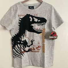 Athletic Gray Cotton Shirt With Printed T. Rex Skeleton Graphic T Rex Skeleton, Minion Shirts, Dinosaur Tshirt, World Graphic, Universal Shirts, Skeleton Graphic, Simpsons T Shirt, Harry Potter Shirts, Movie Tees