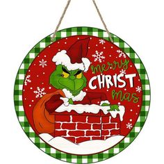 a christmas sign hanging from the side of a brick wall with an image of dr seuss