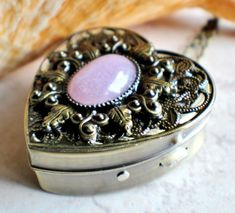 a heart shaped box with a pink stone in it