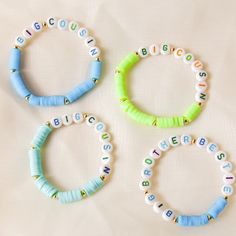 three bracelets with letters on them sitting next to each other