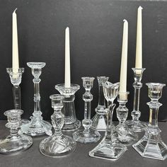 an assortment of glass candlesticks and candle holders