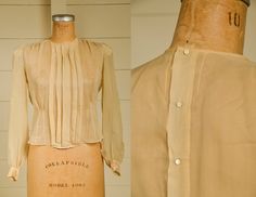 "Antique Silk Blouse Sheer Ivory Button Back Pleated Deco Blouse Beautiful silk blouse. Pleated front with a fitted waistline. Back has metal snap closures with pearl button coverings. Shows normal signs of wear. Measurements shoulders: 13 3/4'' chest: 36\" waist: 33\" length: 20\" sleeve: 23''" Cream Button Closure Blouse For Work, Cream Buttoned Top For Work, Cream Blouse With Button Closure For Work, Cream Workwear Blouse With Button Closure, Pearl Button-up Blouse For Work, Classic Formal Blouse With Pearl Buttons, Formal Button-up Blouse With Pearl Buttons, Workwear Blouse With Pearl Buttons, Classic Blouse With Pearl Buttons