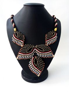 "Original beautiful beaded necklace in black and red gold. Beadwork. The modern design of the necklace will emphasize your individuality and originality, beads will complement any look. This necklace made of delicate leaves suits any outfit. Jewelry for women. An unusual gift for a friend. The size of the necklace is 45 cm (17.71 \"). Three Leaf Pendant Length 9 cm (3.54 \") If you have any questions for me, please contact me. Thanks for watching and interest in my work." Bright Necklace, Embroidery Modern, Beautiful Beaded Necklaces, Modern Jewellery Design, Outfit Jewelry, Unusual Gift, Leaf Jewelry, Jewelry Beads, Necklace Women