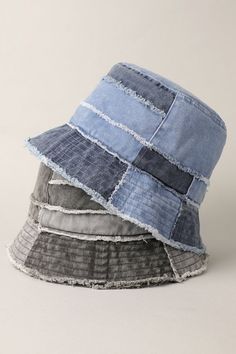 three different colored hats stacked on top of each other, one is blue and the other has grey