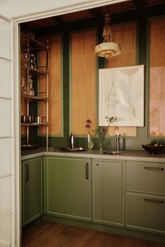 a kitchen with green cabinets and wooden floors