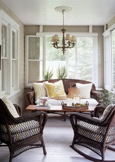 a living room with wicker furniture and white walls in the background is an open porch