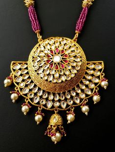 Look beautiful and feel beautiful wearing this gorgeous Indian kundan and pearl pendant necklace in chandbali design. Bright yellow gold colored crescent moon surrounds a stunning pattern of tear drop shaped kundan, which catches the light so nicely! The necklace is outstanding - lush and full multi strand necklace of sparkly faceted red crystals alternating with glowing, delicate tiny pearls. Matching jhumka earrings with pearls and red crystal accents, and clear and red stones. Effect is stunn Eid Round Kundan Temple Necklace, Chandbali Necklace With Latkans For Diwali, Festive Kundan Temple Jewelry Necklace With Round Pendant, Festive Chandbali Kundan Necklace Gift, Festive Temple Jewelry Kundan Necklace With Round Pendant, Festive Temple Style Kundan Necklace With Round Pendant, Diwali Kundan Necklace Pendant With Latkans, Kundan Chandbali Necklaces For Celebrations, Chandbali Kundan Necklaces For Celebrations