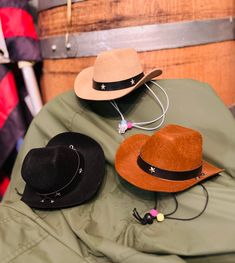 three hats sitting on top of a table next to a wooden barrel filled with other items