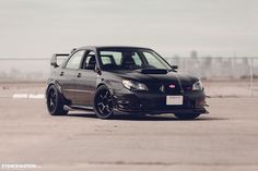 a black car parked in an empty parking lot