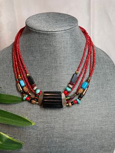 This vintage Chicos necklace would be great with anything dress up dress down. It's made of plastic beads and some other pearl. Some turquoise stones from the red beads are multi strand. There's 55 strands. It has an extender chain good looking necklace.  Great condition Bohemian Red Coral Beaded Necklace With Polished Beads, Vintage Red Gemstone Beads, Multi-strand Red Coral Beaded Necklace As Gift, Multi-strand Red Coral Beaded Necklace For Gift, Bohemian Red Necklace With Black Beads, Traditional Red Necklaces With Black Beads, Traditional Red Necklace With Black Beads, Red Bohemian Choker With Colorful Beads, Bohemian Red Choker With Colorful Beads