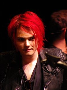 a young man with red hair wearing a leather jacket