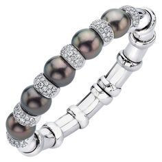 Flexible Tahitian black pearl bangle accented with white diamonds and set in 18-karat white gold. The inside measurement of the bracelet is 2 5/8" wide x 2 1/4" height. Total diamond weight 2.00 carats 5 Tahitian Pearls 12mm x 11.6 mm Stamped 750 18K Cellini Black Pearl Jewelry, Tahitian Pearl Bracelet, Wedding Jewellery Designs, Natural Pearl Jewelry, Black Pearls, Tahitian Black Pearls, Antique Bracelets, Pearl Bangle, Gold Bracelet Cuff