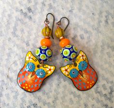 Whimsical owl earrings featuring delightful orange, yellow and blue enamel charms. I love their big mesmerizing eyes. They are topped with spotted blue, green and yellow lampwork beads, bright orange glass spacers, copper beads and yellow Czech glass beads. These earrings measure 2 3/4 inches in total length and hang on niobium earring hooks. Return to shop: bstrung.etsy.com More links where you can find me: Facebook: http://www.facebook.com/bstrung Pinterest: http://pinterest.com/bstrung Instag Blue And White Earrings, Mesmerizing Eyes, Whimsical Owl, Lampwork Earring, Polymer Earrings, Owl Earrings, Creative Eye, Bird Earrings, Animal Earrings