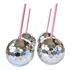 two shiny silver balls with pink straws in them