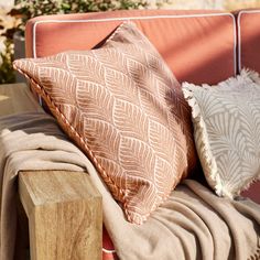 two pillows sitting on top of a wooden bench