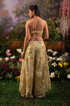 Behold the modern royalty through this Alana co-ord set. The ensemble comprises a bralette blouse paired with unconventional wide-legged pants and a heavily embellished cape. The monochrome outfit is highlighted with shiny sequins and beads crafting motifs of flowers and birds resonating a heavenly garden. Deep v-neck bralette attached with rhinestone embellished straps. The hook is attached to the back side of the blouse. Unconventional wide-legged pants with attached rhinestone straps at the w Modern Royalty, Monochrome Outfit, Bird Motif, Co Ord Set, Floral Applique, Co Ord, Deep V Neck, Bead Crafts, Beaded Embroidery