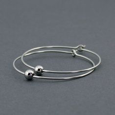 Handmade, minimalist hoop earrings. ‣ handmade, polished earring hoops with a single, 4 mm bead on each hoop ‣ material: 316L stainless steel ‣ size: hoop ⌀: 1.3" / 3.3 cm Minimalist Hoop Sterling Silver Bracelets, Minimalist Sterling Silver Hoop Bracelets, Simple Hypoallergenic Dangle Hoop Earrings, Minimalist Hoop Jewelry With Simple Design, Minimalist Hypoallergenic Metal Hoop Earrings, Minimalist Handmade Hoop Jewelry, Minimalist Hypoallergenic Dangle Hoop Earrings, Minimalist Adjustable Hoop Jewelry, Minimalist Nickel-free Hoop Jewelry