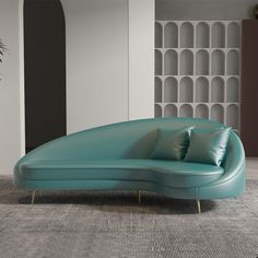 a large blue couch sitting on top of a carpeted floor next to a potted plant